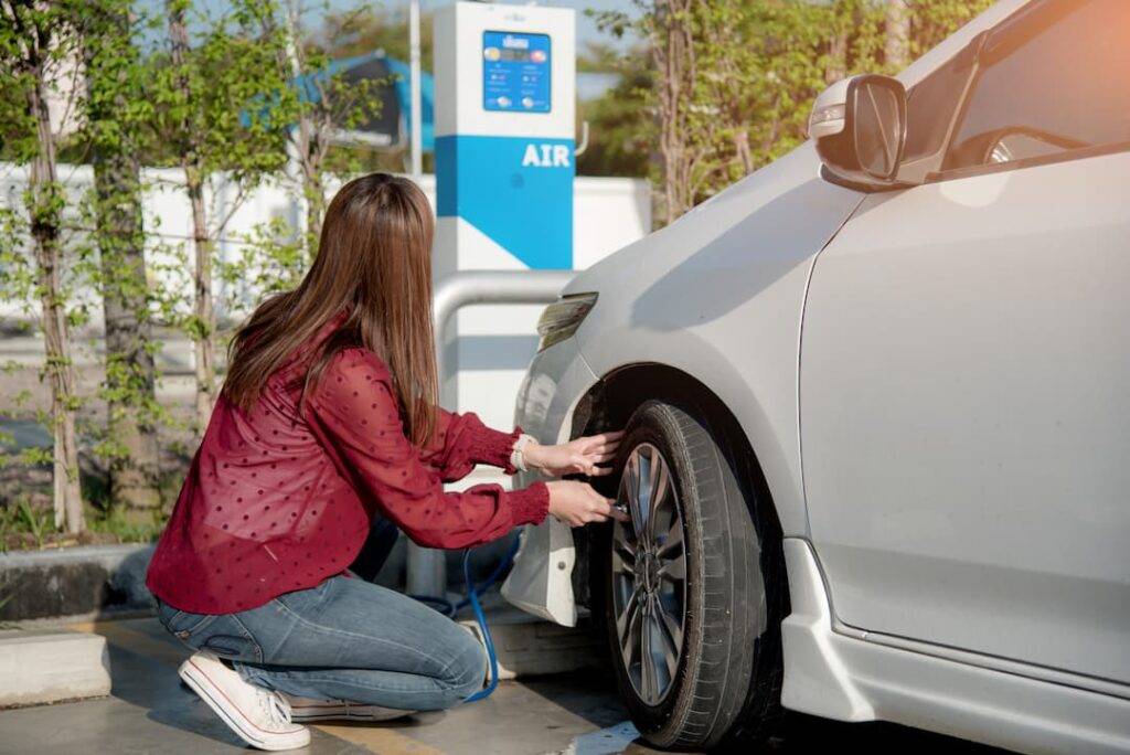 woman checking tyre pressure